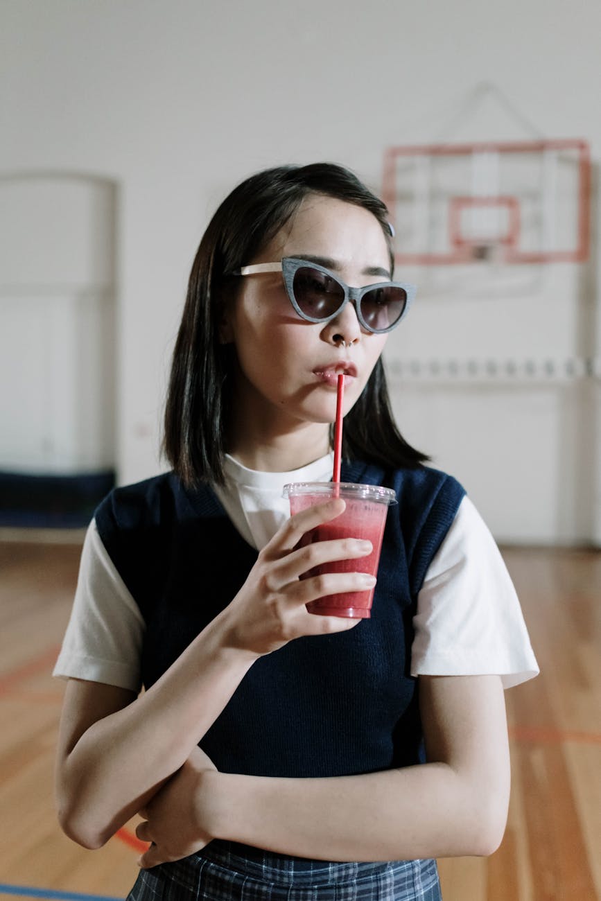 schoolgirl drinking smoothie in school gym