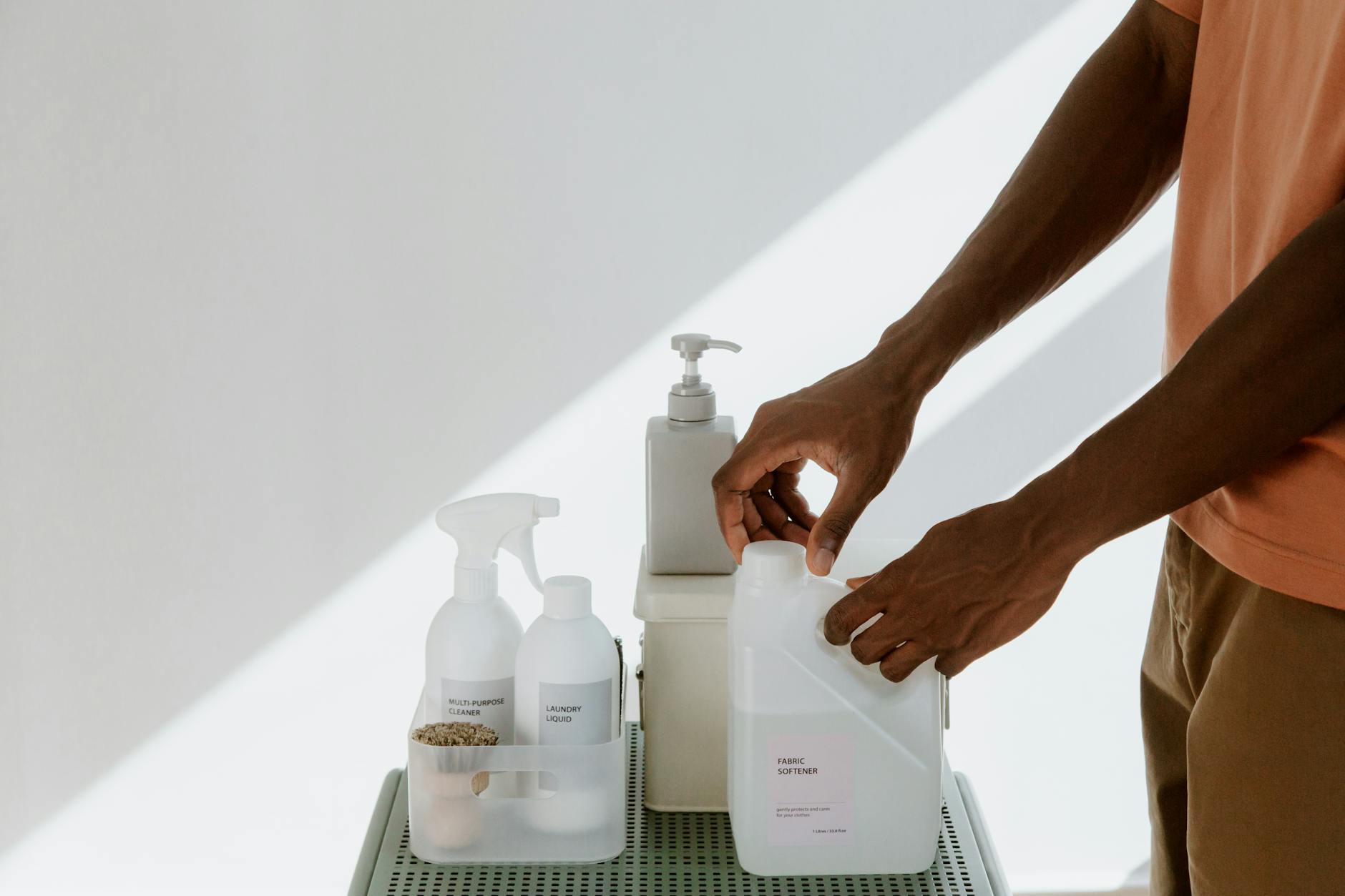 hand opening cleaning product against white wall