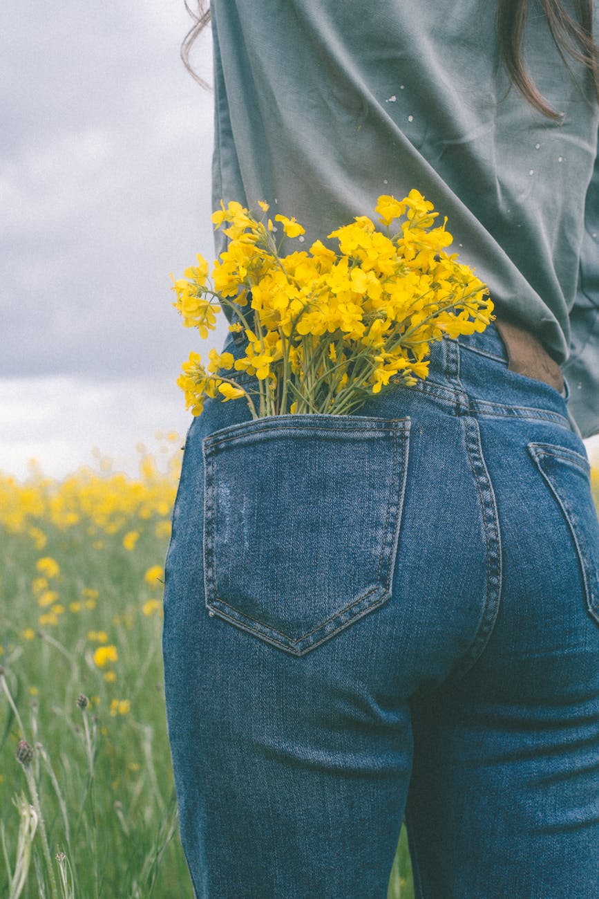person wearing denim jeans with yellow flowers in pocket