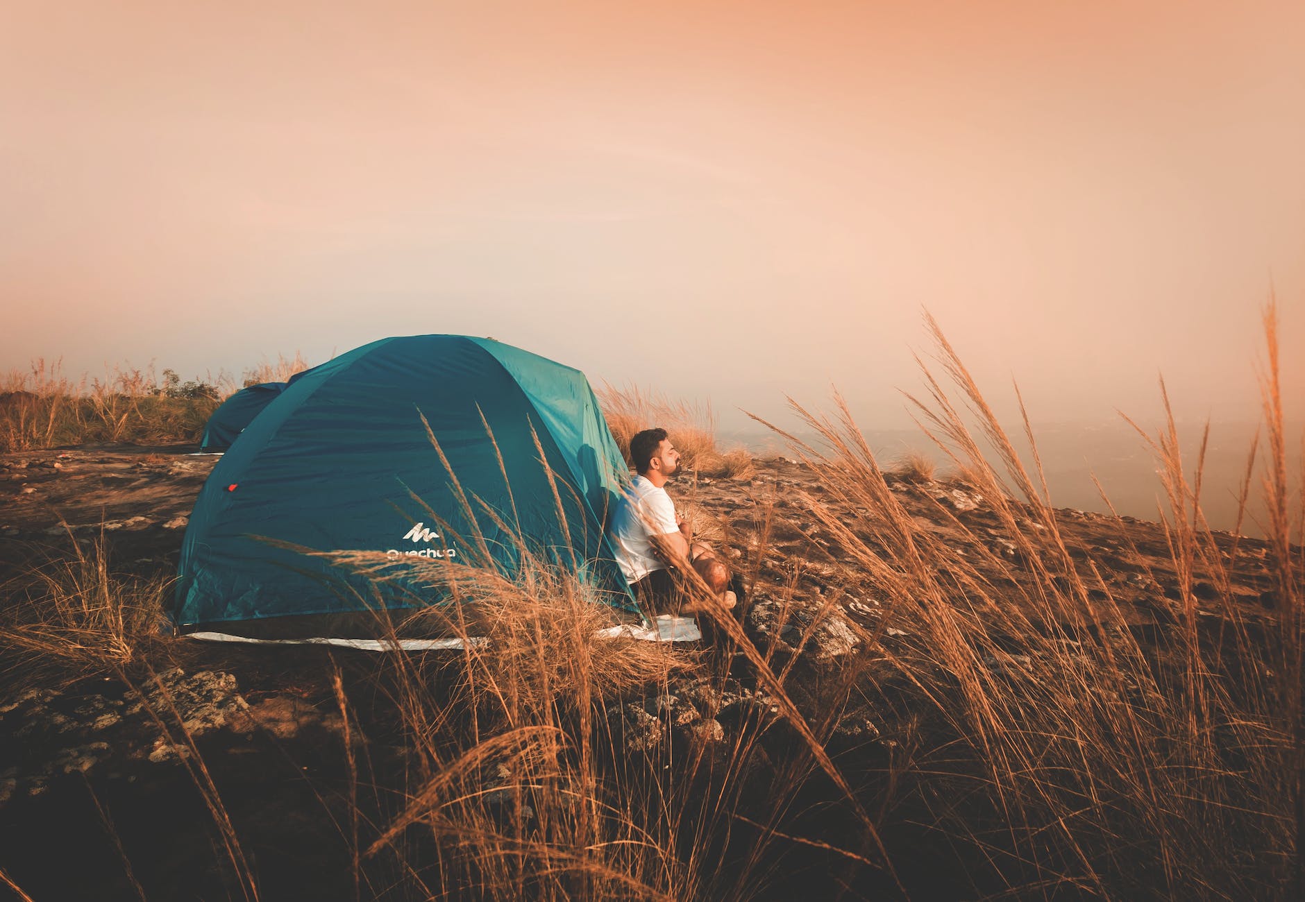 photo of a man sitting outside the tent