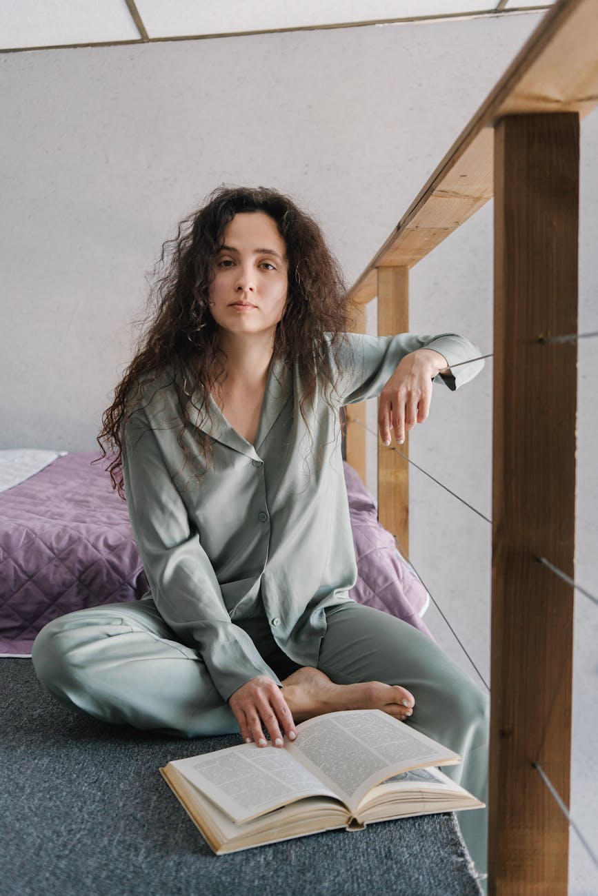 woman in gray robe sitting on bed