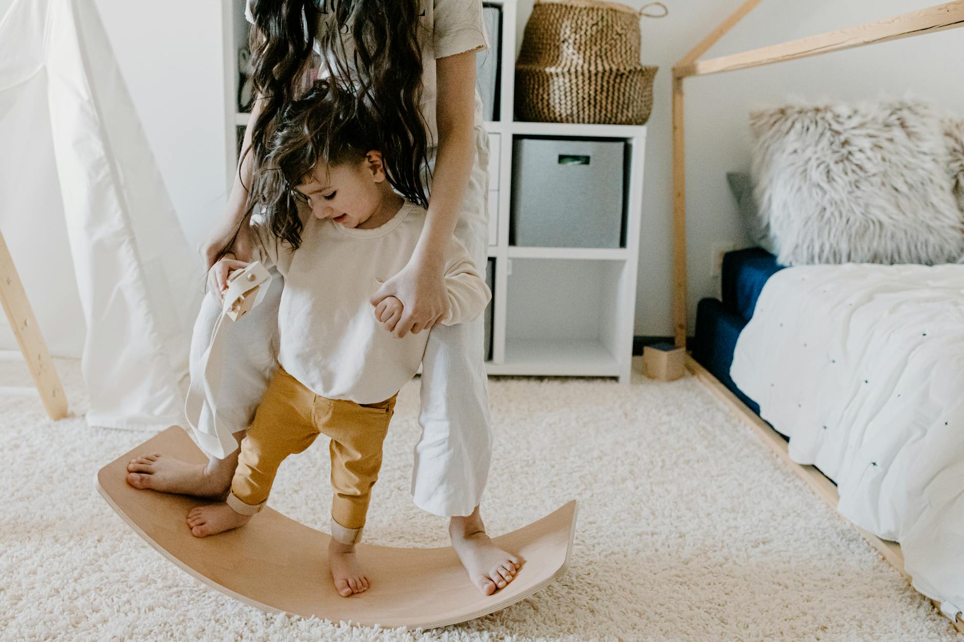 mother and son standing on a wooden balancer board